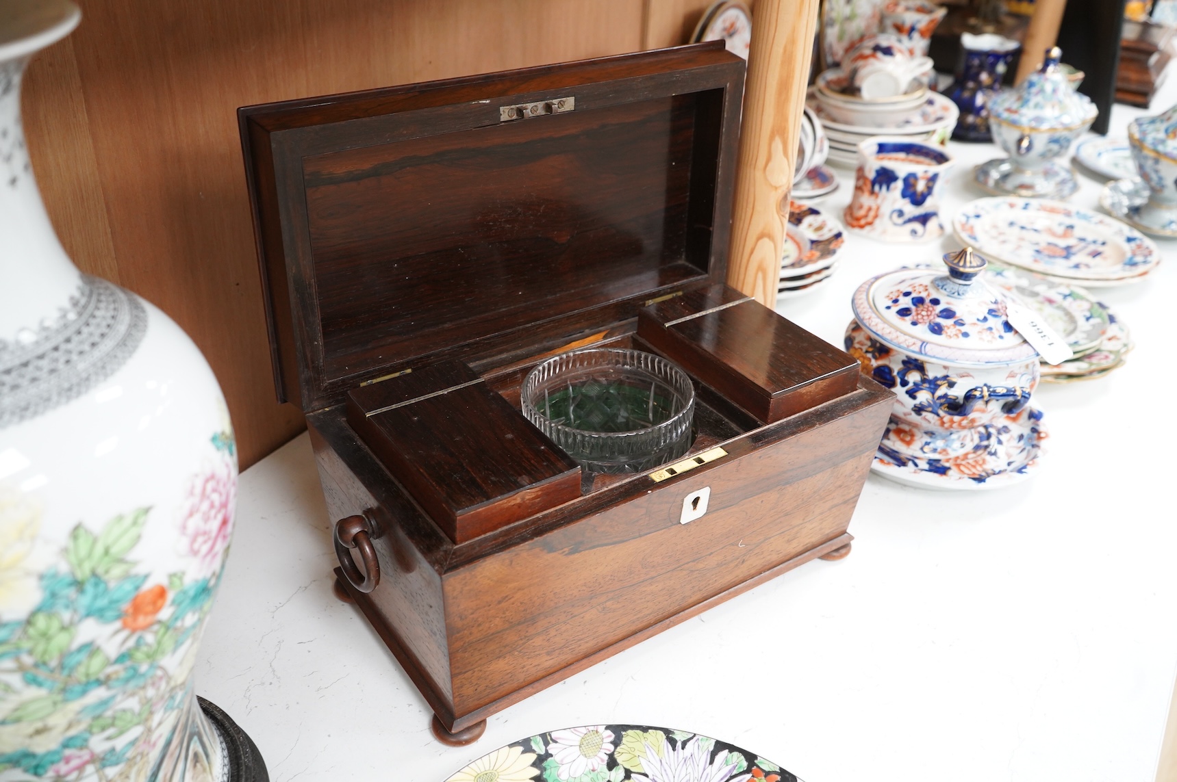 A William IV rosewood sarcophagus shaped tea caddy with glass liner, 33cm wide
